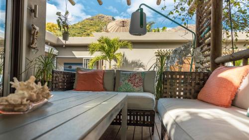 a patio with a wooden bench and pillows at Villa Sartelo in Tamarin