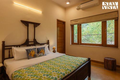 a bedroom with a bed and a window at StayVista's Wildwood Canopy - Forest-View, Pet-Friendly Villa with Lawn & Indoor-Outdoor Games in Jaipur