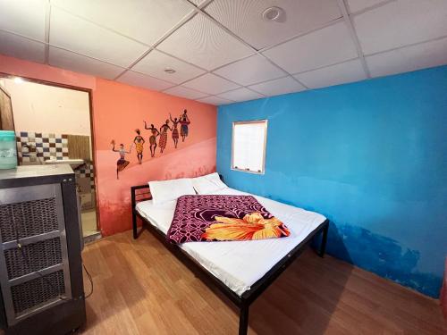 um quarto com uma cama com uma parede colorida em The Best Memory Camp em Rishikesh