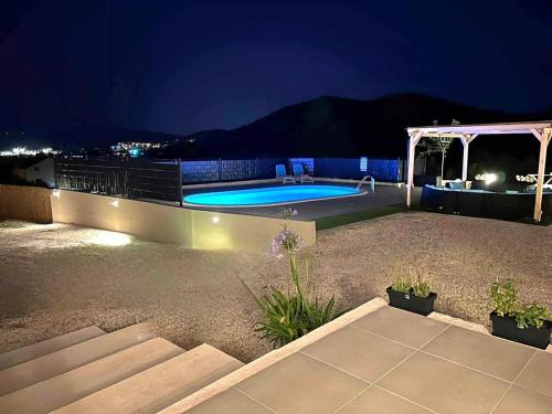 ein Schwimmbad in einem Garten in der Nacht in der Unterkunft Family friendly house with a swimming pool Sibenik - 21484 in Šibenik