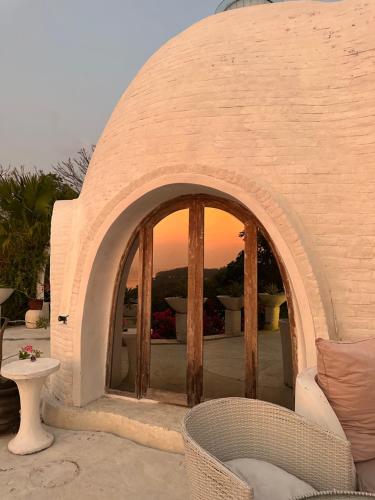 a building with an archway with a chair and a table at Villa Wisdome 1 Bedroom in Teluk Nara
