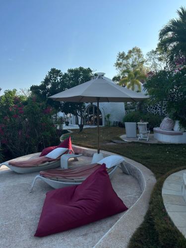 a group of chairs and an umbrella in a yard at Villa Dreamdome in Teluk Nara