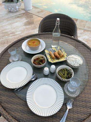 a table with plates of food and a bottle of water at Villa Wisdome 1 Bedroom in Teluk Nara