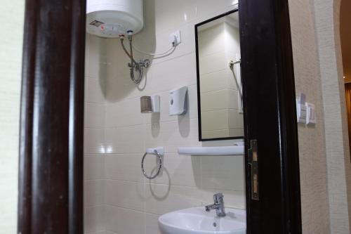 a bathroom with a sink and a mirror at فندق ضيوف المقام للغرف والشقق المفروشة in Mecca