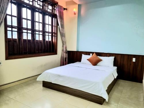 a bedroom with a bed with white sheets and a window at Ha Giang Donkey hostel in Ha Giang
