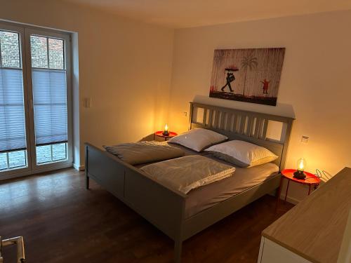 1 dormitorio con 1 cama con 2 mesas y 2 lámparas en Ferienwohnung Grefenhof en Meerbusch