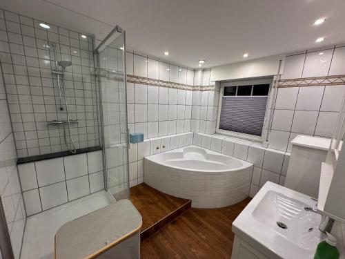 Ferienwohnung Grefenhof في ميربش: حمام مع حوض استحمام ودش ومغسلة