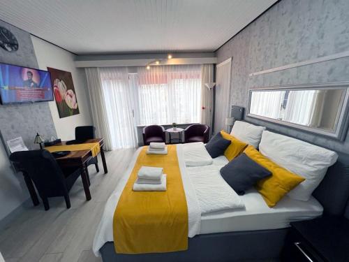 a bedroom with a large bed with yellow and blue pillows at Strandnest Büsum in Büsum