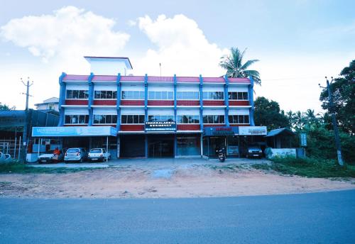 a large building with cars parked in front of it at Chakalakkal Residency in Sultan Bathery