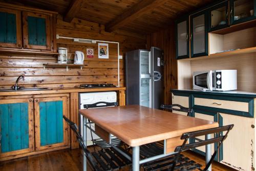 una cocina con mesa y sillas en una cabaña en les lys plaine des cafres, en Le Tampon