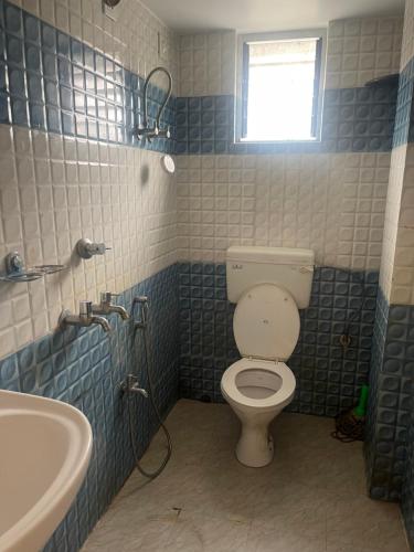 a bathroom with a toilet and a sink at Lakeview Apartments Homestay in Agartala