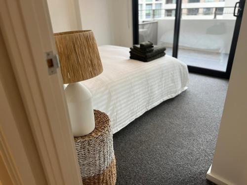 1 dormitorio con 1 cama con lámpara en una mesa en NEW BOUTIQUE 1bd Apt en Canberra