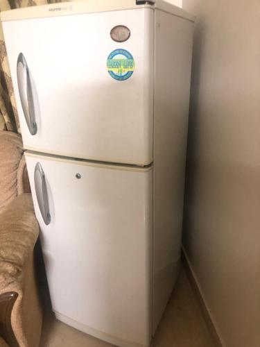 a white refrigerator in a room with at Ayub House in Karachi