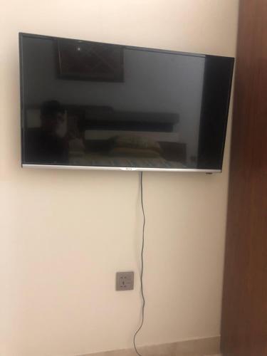 a flat screen tv hanging on a wall at Ayub House in Karachi