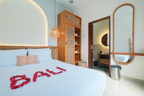 1 dormitorio con cama blanca y espejo en Felgio Villa Jimbaran en Ungasan