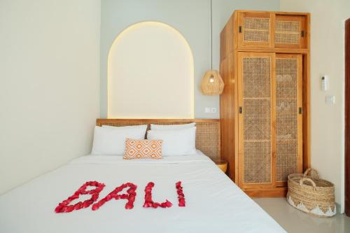 a bedroom with a bed with a ball sign on it at Felgio Villa Jimbaran in Jimbaran