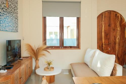 a living room with a couch and a tv at Felgio Villa Jimbaran in Jimbaran