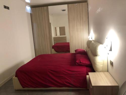 una camera con letto rosso e specchio di Alla palazzina a Volano