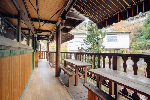 a deck with benches and tables on a balcony at Hotel Morgenrot in Kobe