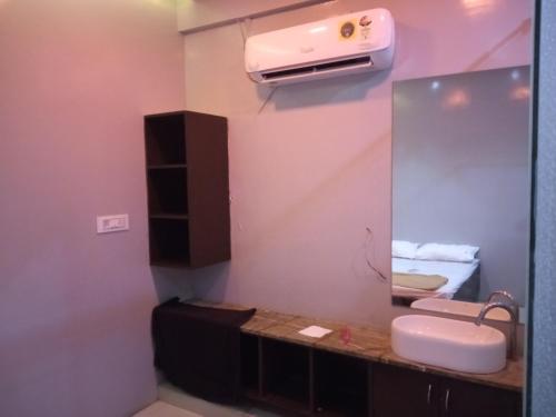 uma casa de banho com um lavatório e um espelho em Hotel Nova Rooms em Surat