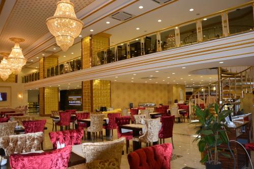 a restaurant with red chairs and tables in a building at Haldi Otel in Van