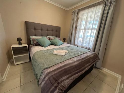 a bedroom with a large bed with a window at #One6Eight in Hermanus