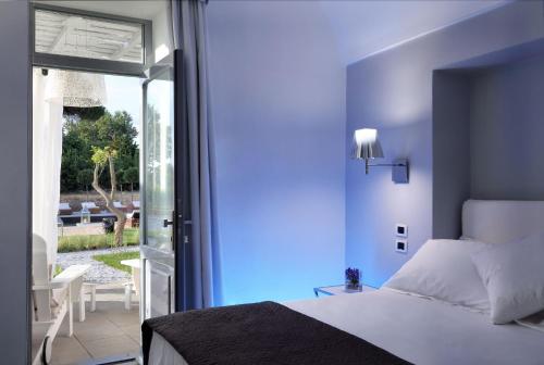 um quarto com uma cama e uma porta de vidro deslizante em La Suite Boutique Hotel em Procida