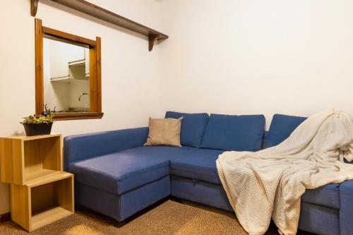 un divano blu in una stanza con specchio di BeSt Alce a Sestriere