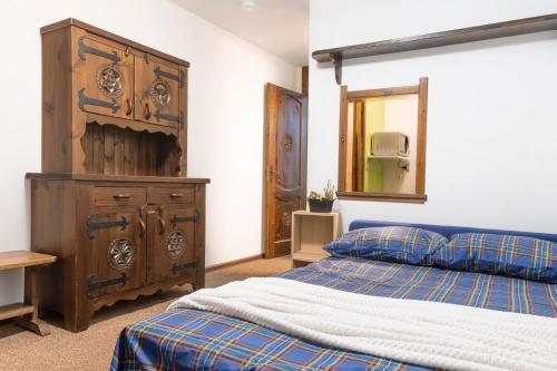 1 dormitorio con cama y tocador de madera en BeSt Alce en Sestriere