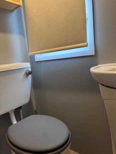 La salle de bains est pourvue de toilettes blanches et d'un lavabo. dans l'établissement BLW 04, à Great Billing