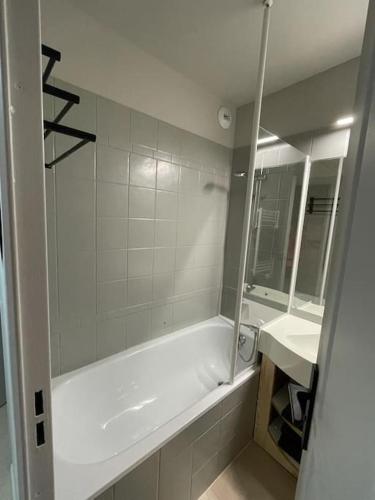 une salle de bain blanche avec une baignoire et un lavabo dans l'établissement f2 28 m2 n°405 5 personnes ski au pied/piscine, à Valmeinier