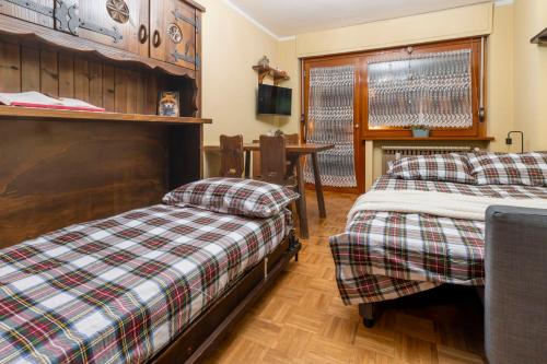 a bedroom with two beds and a table in it at BeSt Volpe in Sestriere