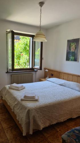 a bedroom with a bed with two towels on it at CASA LENA Tra lago e monti in Mezzolago