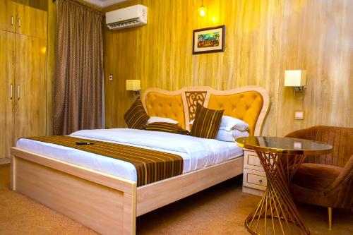um quarto com uma cama, uma mesa e uma cadeira em ERiTH APARTMENT & SUITES em Ikeja