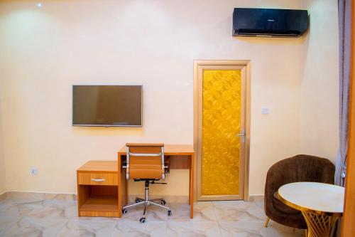 a room with a desk and a tv and a chair at ERiTH APARTMENT & SUITES in Ikeja