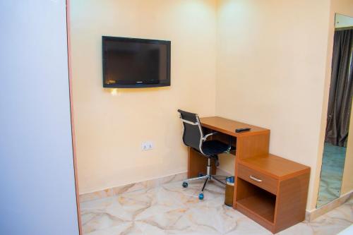 a room with a desk and a television on the wall at ERiTH APARTMENT & SUITES in Ikeja