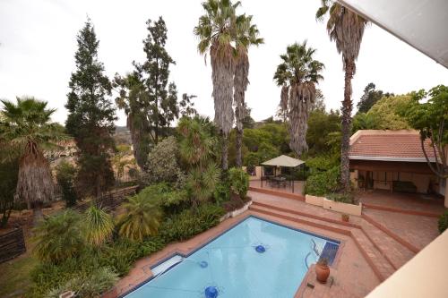 an overhead view of a swimming pool with palm trees at Attaché Guest Lodge & Health Spa in Midrand