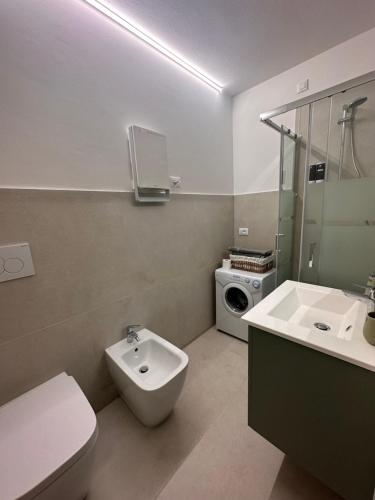 a bathroom with a toilet sink and a washing machine at La Stella in Ponte di Legno
