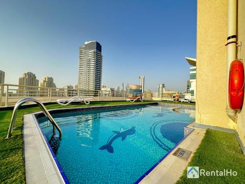 une piscine avec un requin peint sur le côté d'un bâtiment dans l'établissement Brand New Studio w/ Balcony in center of Marina, à Dubaï