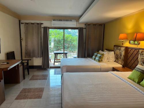 a hotel room with two beds and a desk at Payamai Resort in Ban Nong Nam Khan