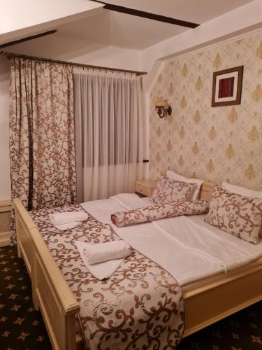 two twin beds in a bedroom with curtains at Pensiunea Mai in Păltiniş