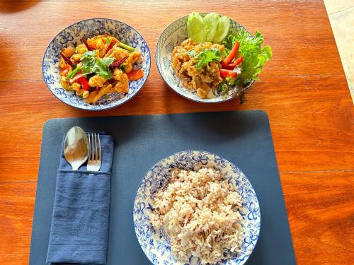 three bowls of food with rice and salad on a table at Nanai Resort Salakphet in Ko Chang