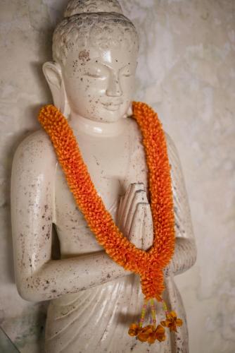 a statue with an orange rope around its neck at Rock'n Reef in Uluwatu
