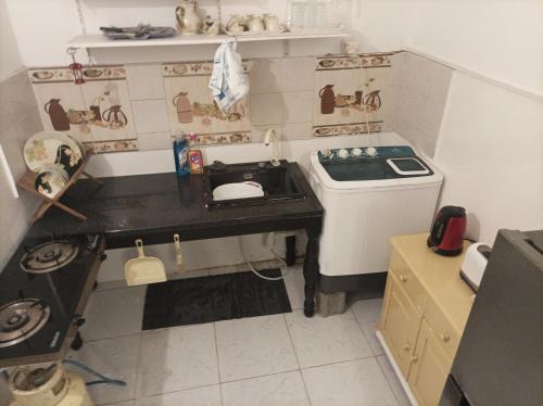 a small kitchen with a stove and a sink at Brise de Mer Appartement meublé in Djibouti