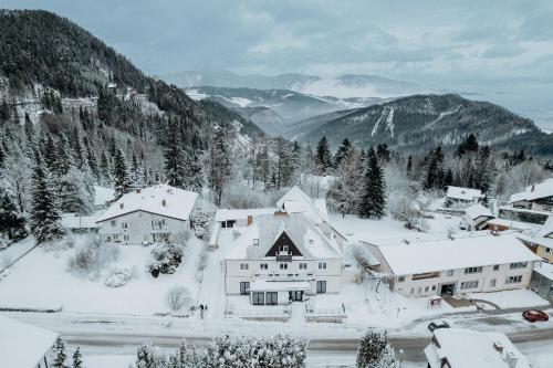 un pueblo cubierto de nieve con montañas en el fondo en Der Löffler am Semmering Bed&Breakfast, en Semmering