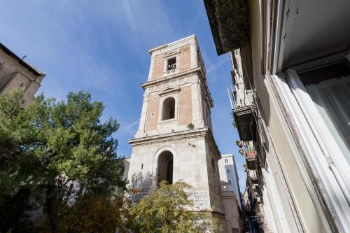 een hoge toren met een klok bovenop een gebouw bij O' Munasterio e Santa Chiara in Napels