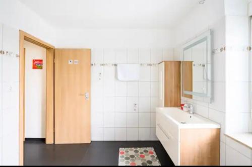 La salle de bains est pourvue d'un lavabo, de toilettes et d'un miroir. dans l'établissement Günstiges Privatzimmer, à Lörrach