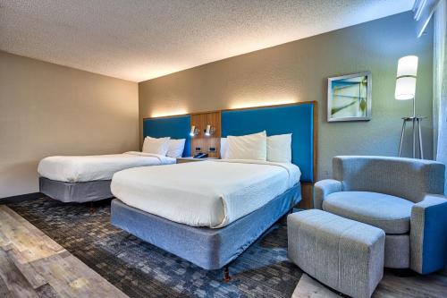 une chambre d'hôtel avec deux lits et une chaise dans l'établissement Courtyard Hampton, à Hampton