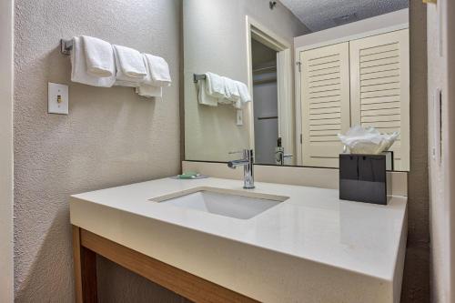 La salle de bains est pourvue d'un lavabo et d'un miroir. dans l'établissement Courtyard Hampton, à Hampton