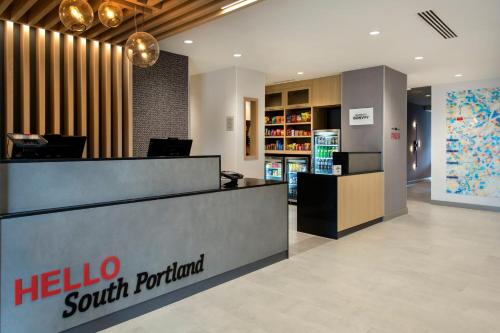 a hotel lobby with a hello south portland store at TownePlace Suites Portland Airport ME in South Portland